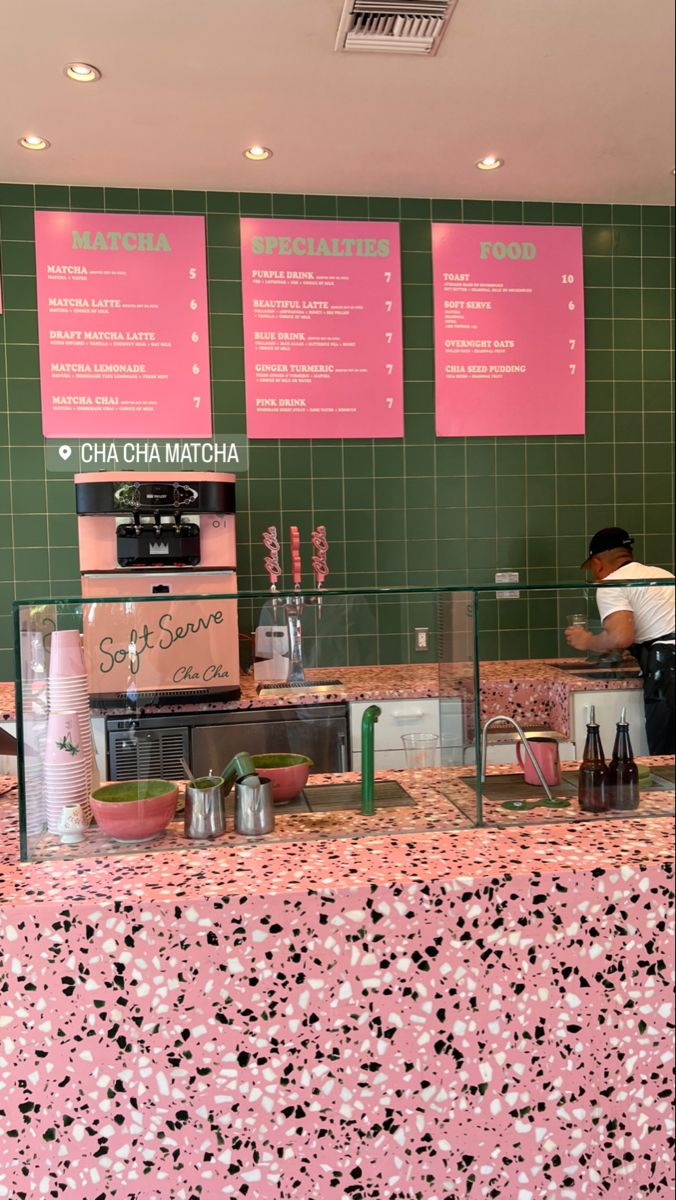 there is a counter in the restaurant with pink and black flowers on it, along with menus