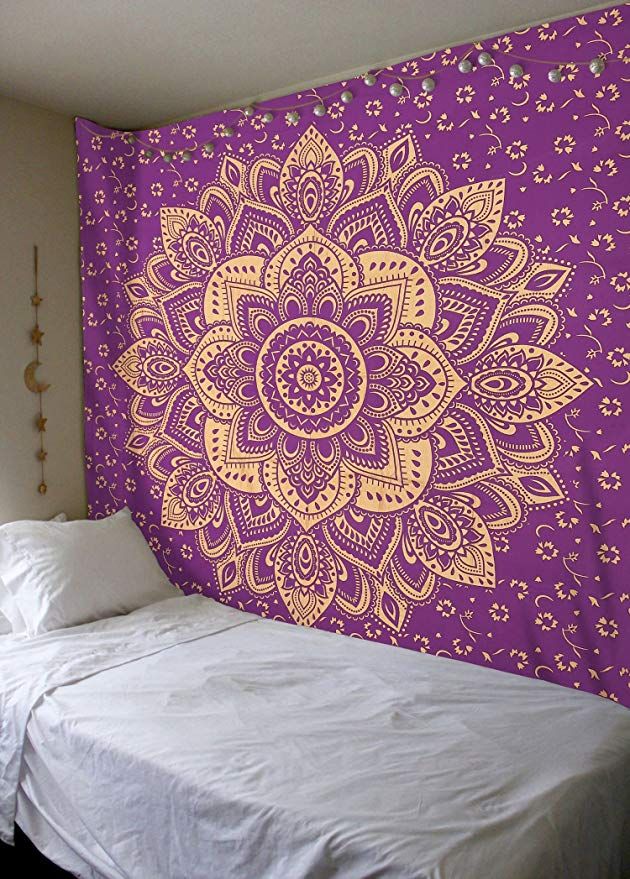 a purple and white wall hanging over a bed in a room with a large flower tapestry on the wall