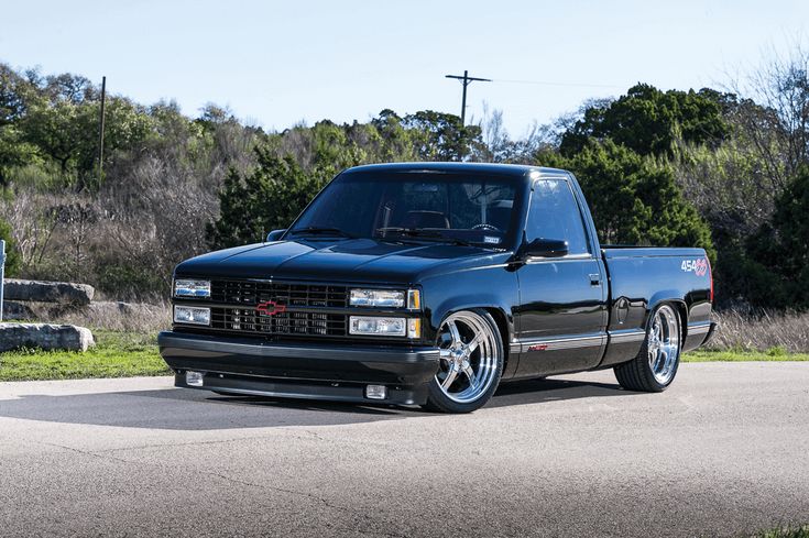 a black truck parked on the side of a road