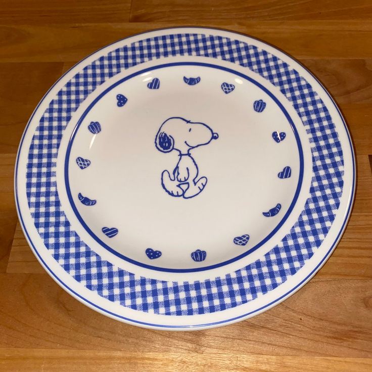 a blue and white plate with a drawing of a dog sitting on it's side