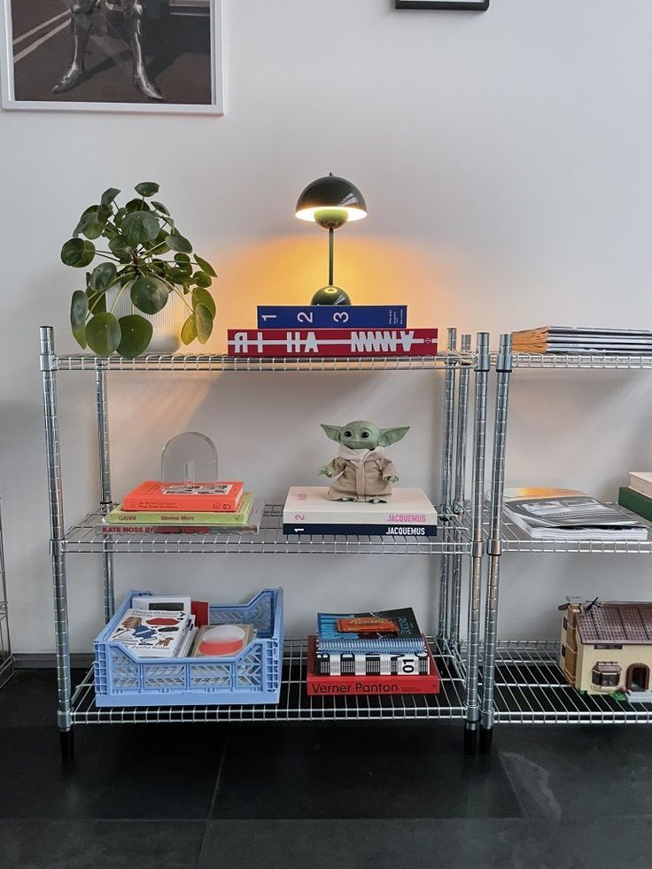 a shelf with books and other items on it in a room next to a lamp