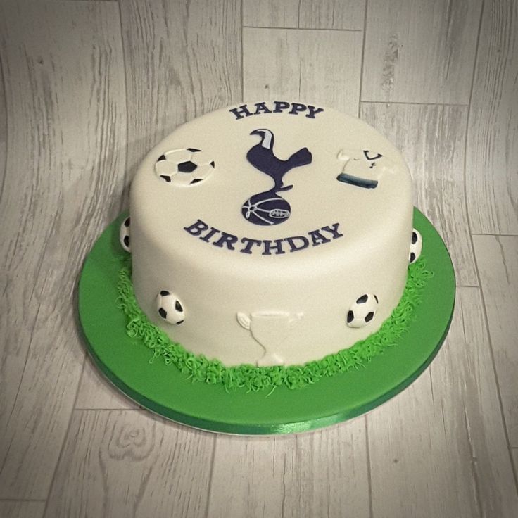 a birthday cake with soccer themed frosting sitting on a green and white platter