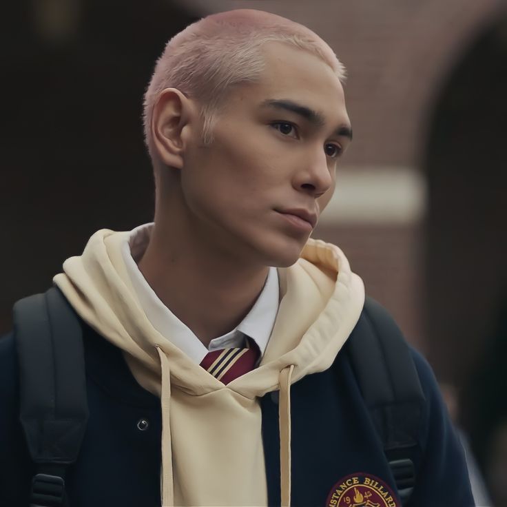 a young man with pink hair wearing a tie and hoodie looking off to the side