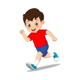 a young boy is running and smiling at the camera while wearing a red shirt and blue shorts