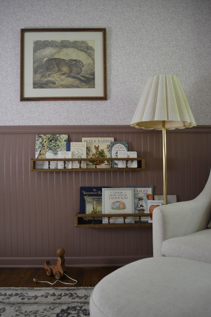 a living room filled with furniture and a lamp on top of a wooden shelf next to a chair