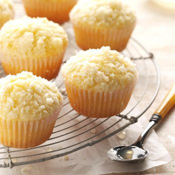 several muffins are cooling on a wire rack with a spoon next to it