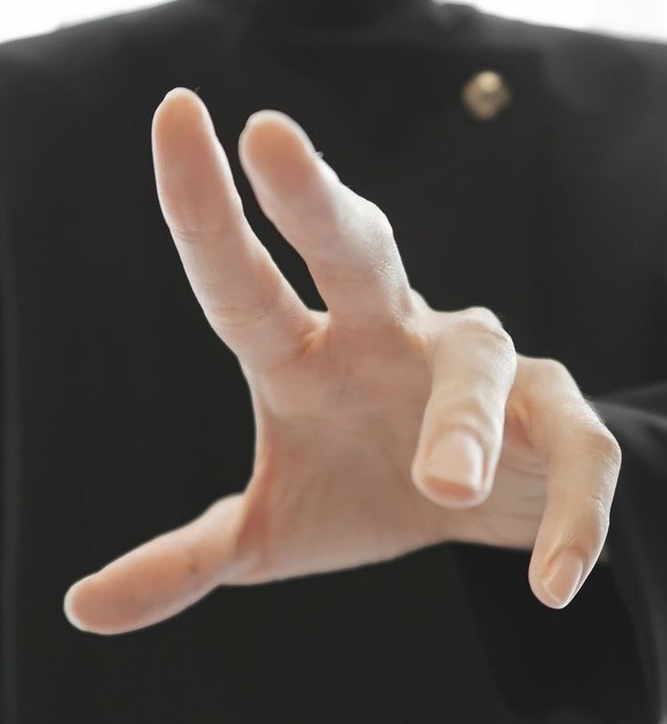 a person in a black shirt is holding their hand up to the camera with both hands