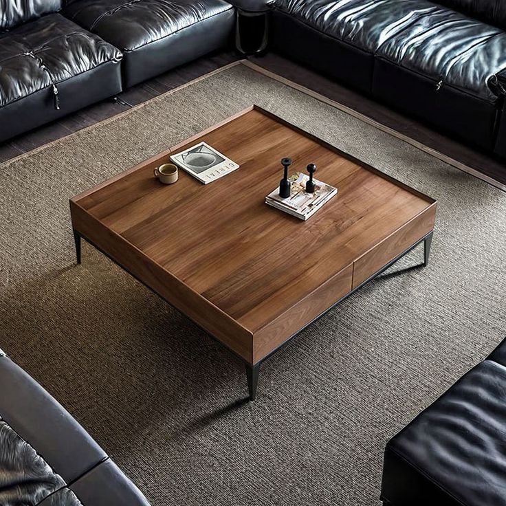 a living room with black leather couches and a wooden coffee table in the middle