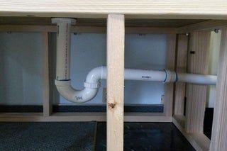 an open cabinet with pipes running through it