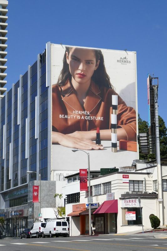 a large billboard on the side of a building with a woman's face painted on it