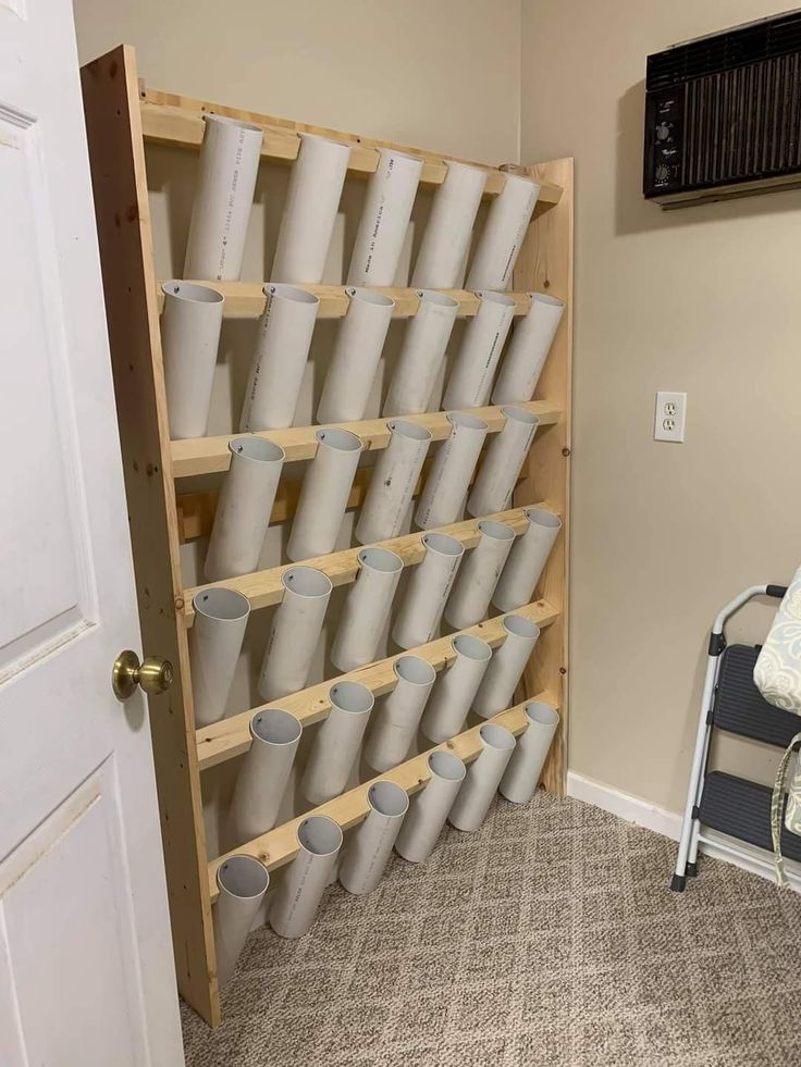 a room with a chair and many cups on the wall next to an open door