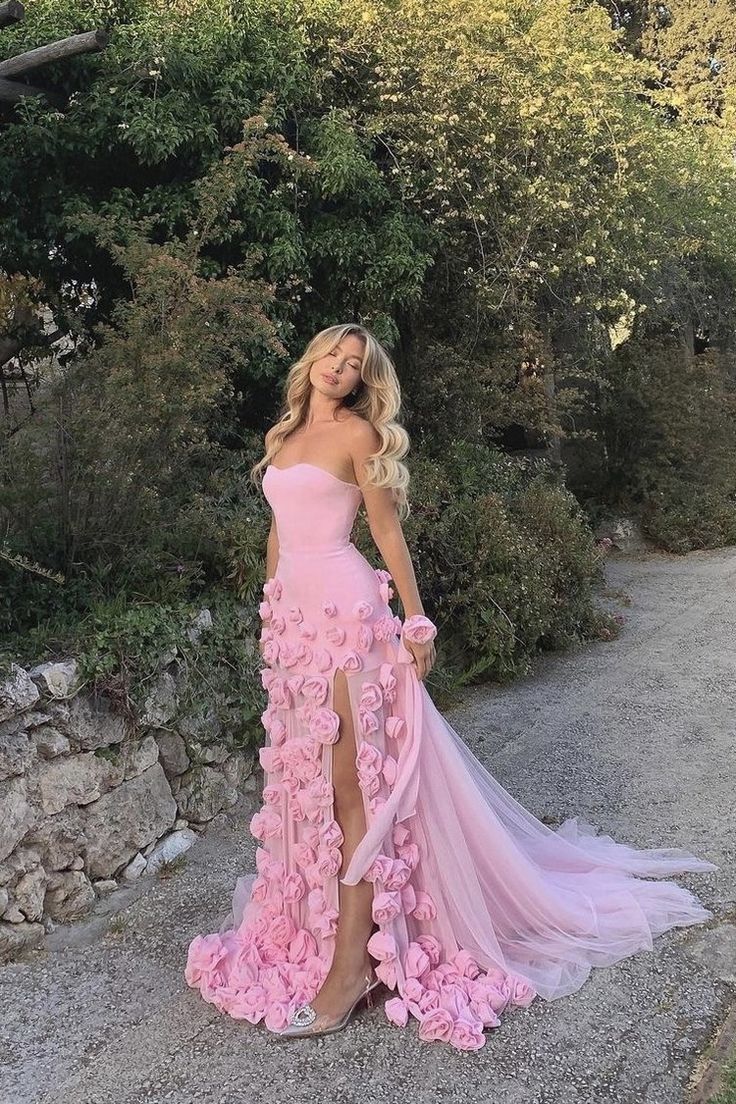 a woman in a pink dress posing for the camera