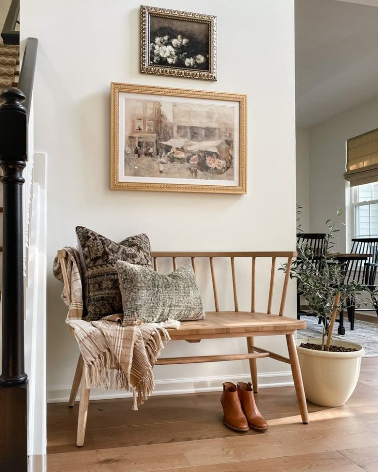 a wooden bench sitting in the middle of a living room next to a stair case