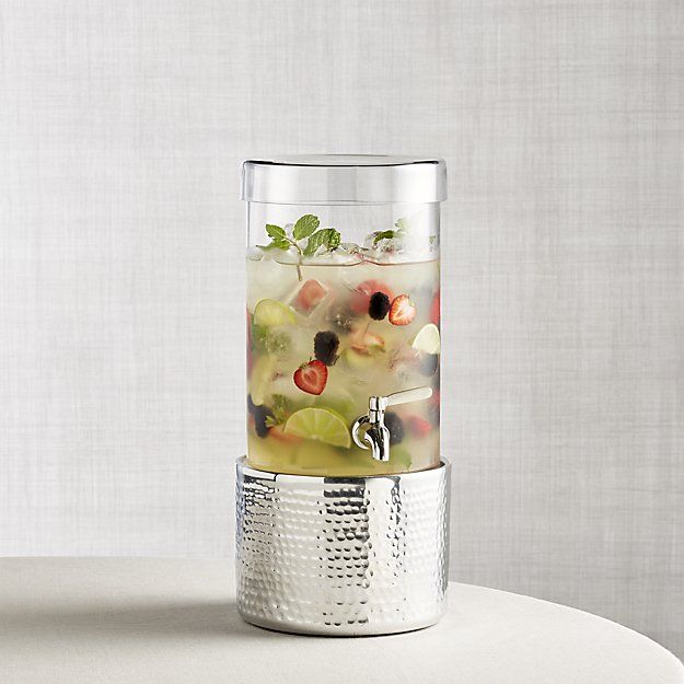 a glass filled with liquid sitting on top of a white table next to a wall