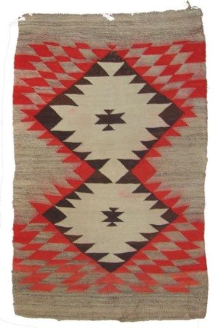 an old navajo rug with red, white and brown colors