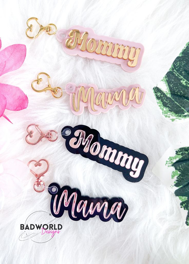 three different colored name tags sitting on top of a white furnishing next to pink flowers