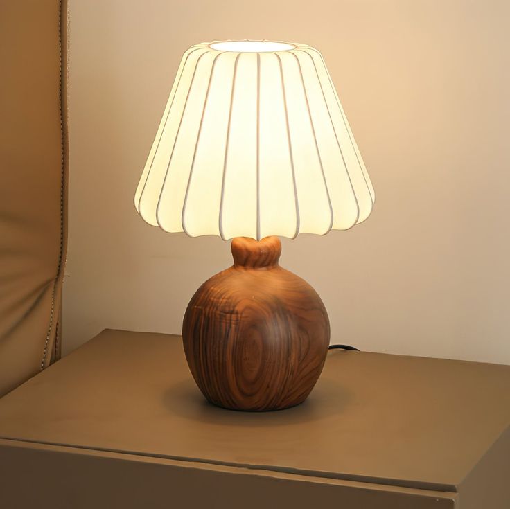 a wooden lamp sitting on top of a table next to a brown chair and wall