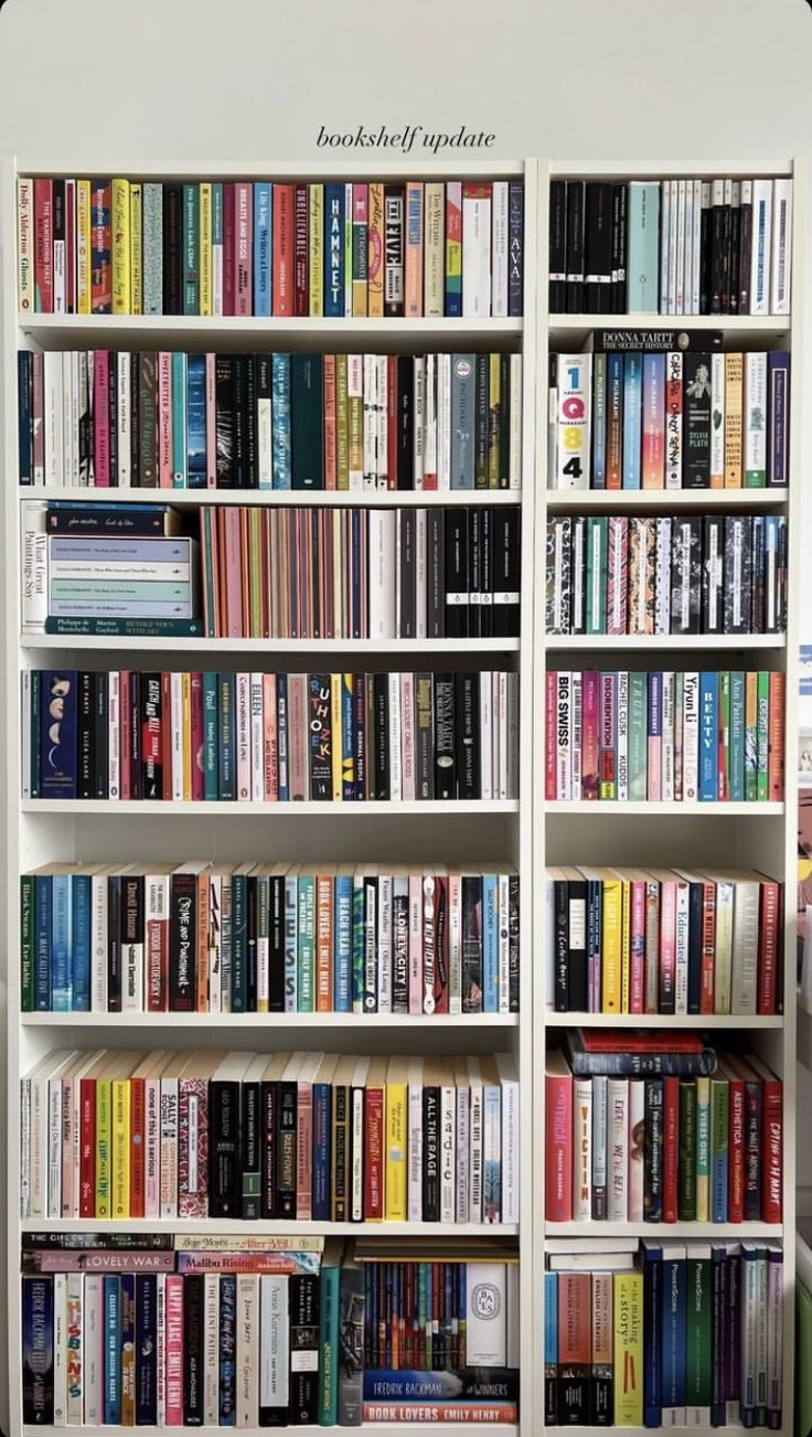 a book shelf filled with lots of different colored books on top of white shelves next to each other