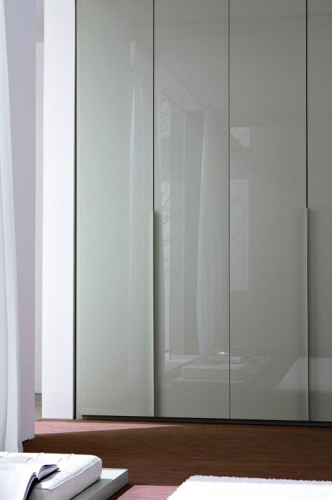 a white closet with sliding glass doors in a room