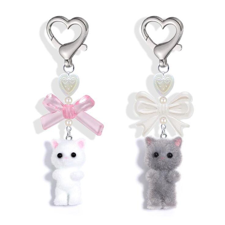 two key chains with small stuffed animals attached to it's sides, one has a heart and the other has a bow