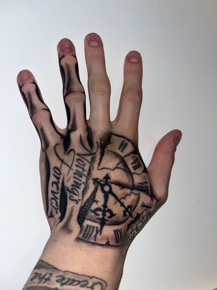 a person's hand with tattoos on it and a clock tattooed on the palm