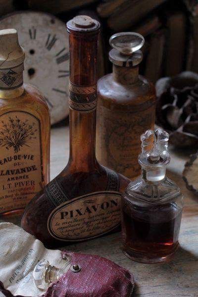 an assortment of old fashioned bottles sitting on top of a table