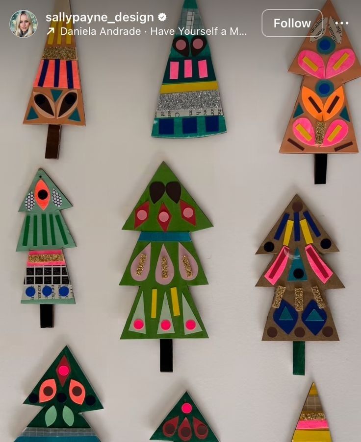 colorful paper christmas trees are hanging on the wall