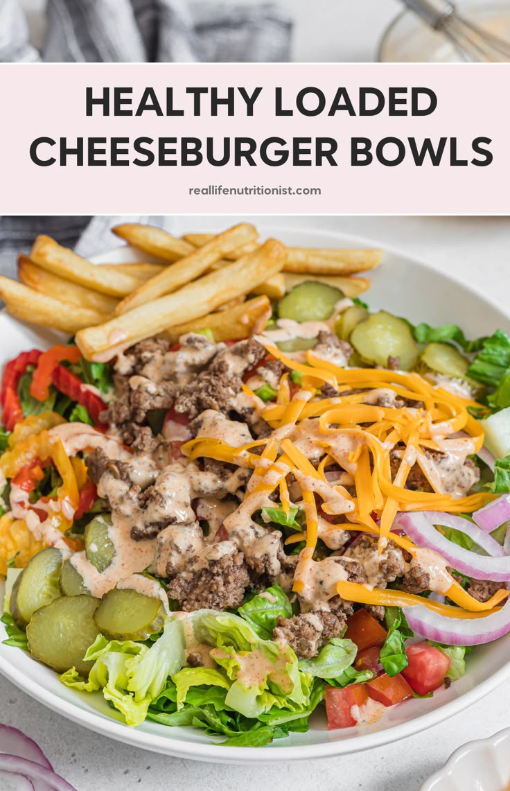 healthy loaded cheeseburger bowls in a bowl with french fries and pickles on the side