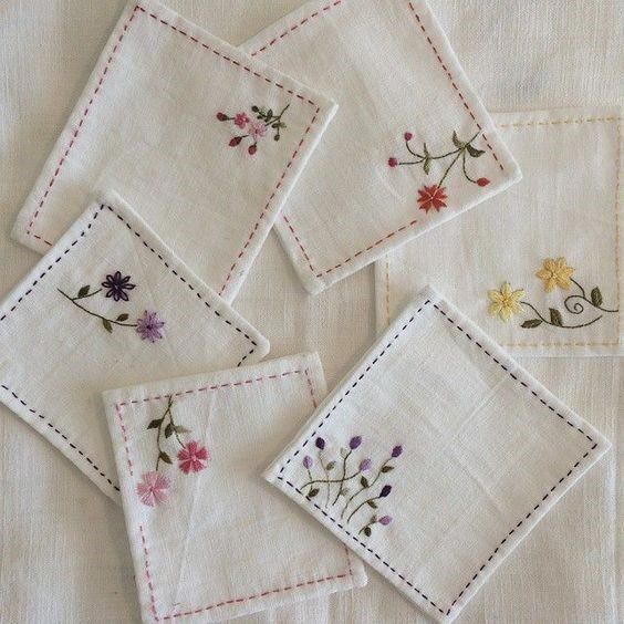 four embroidered napkins with flowers on them