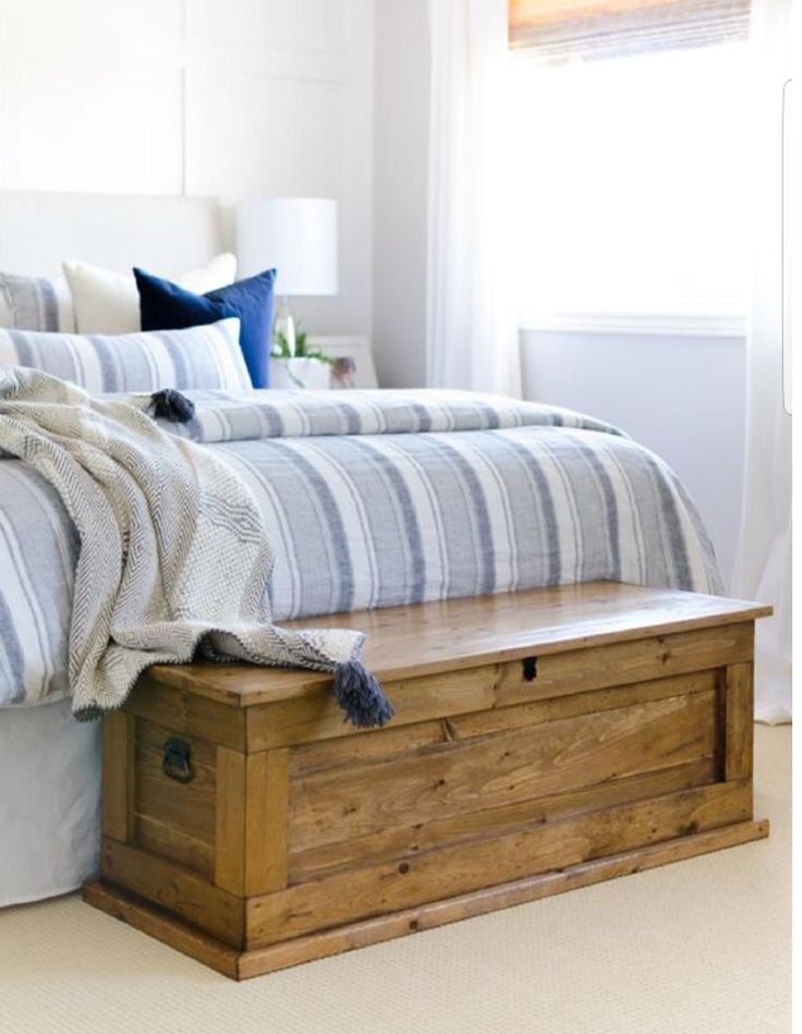 a bed sitting on top of a wooden trunk