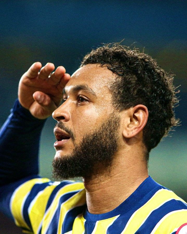 a close up of a soccer player holding his hand on his head and looking off to the side