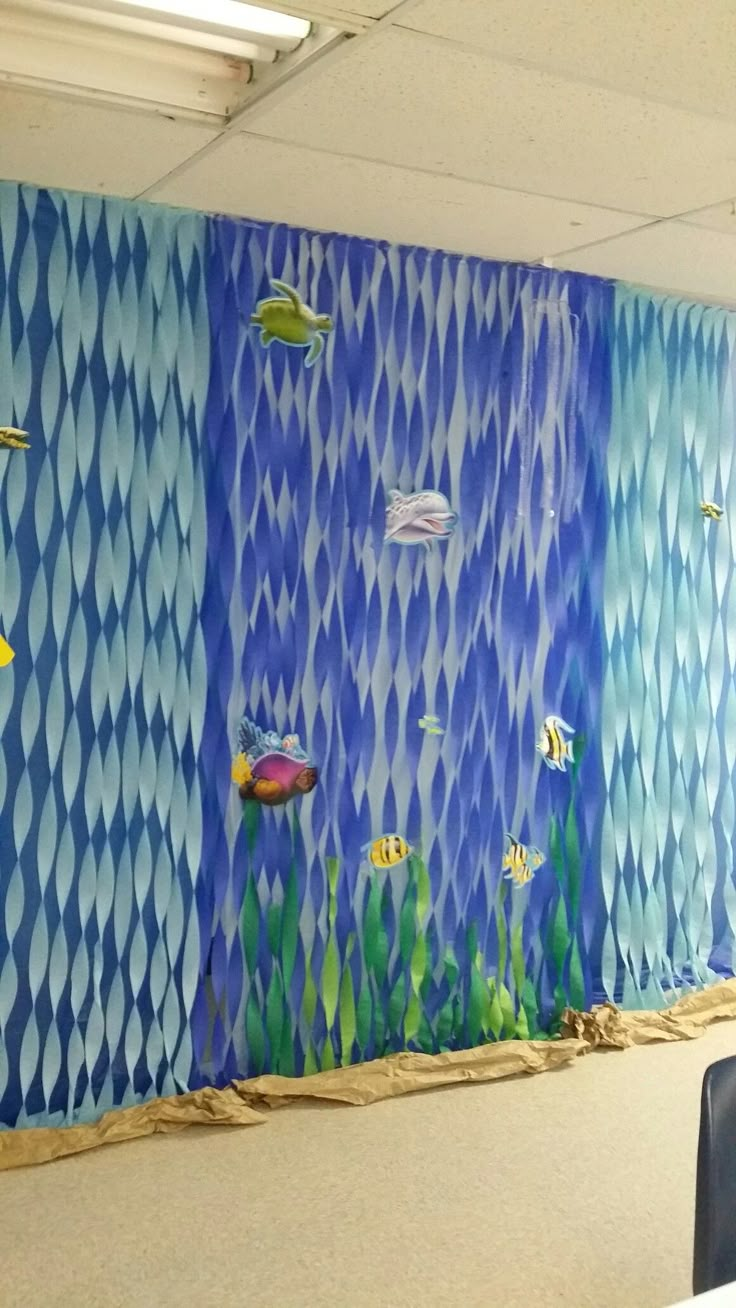 the wall is painted with blue and white fish in an ocean scene, as well as seaweed