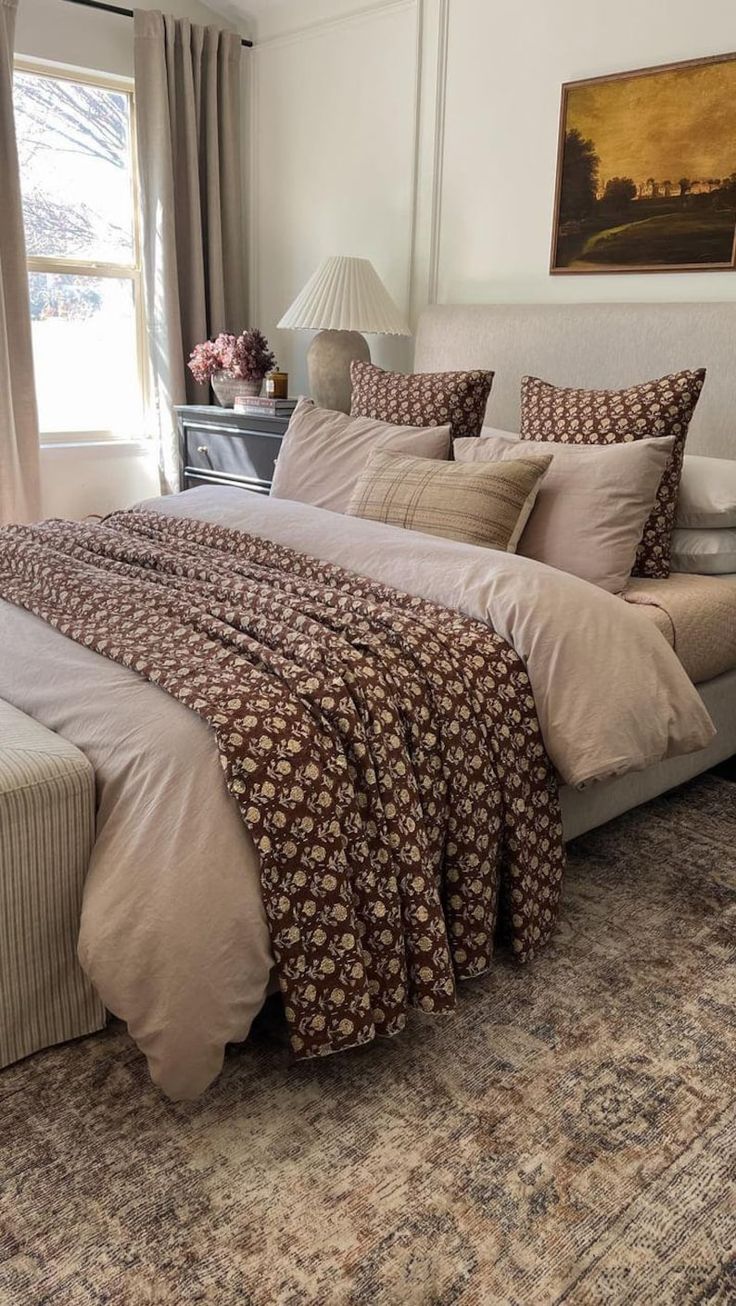 a bedroom with a large bed covered in blankets and pillows