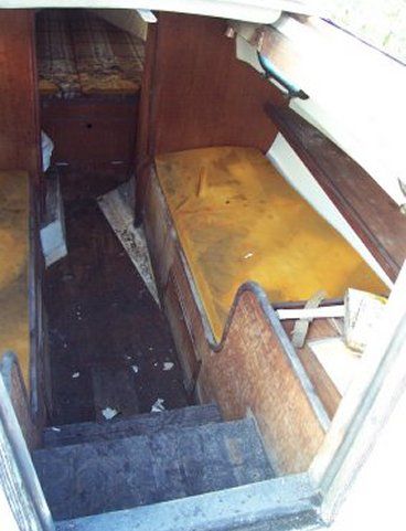 the inside of an old bus with yellow seats and wooden steps leading up to it