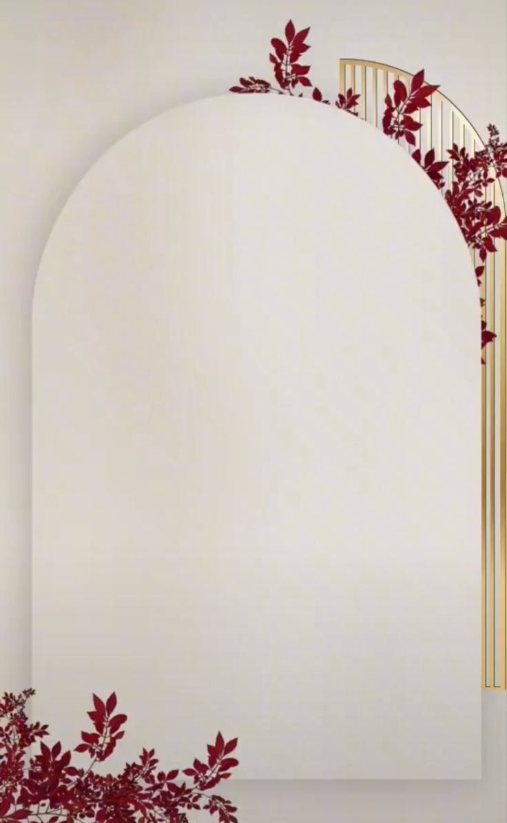 an arch with red leaves on it in front of a white wall and a mirror