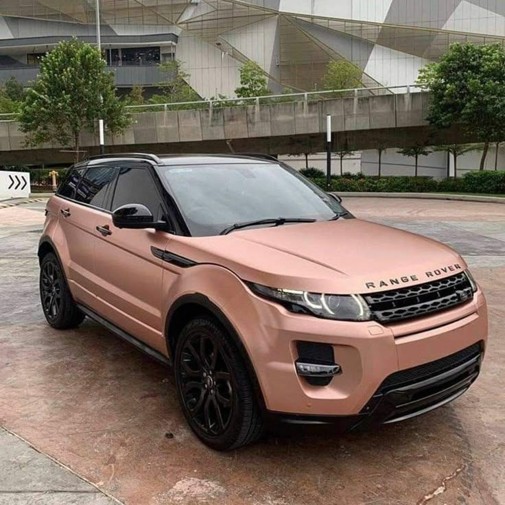 a pink range rover parked in front of a building