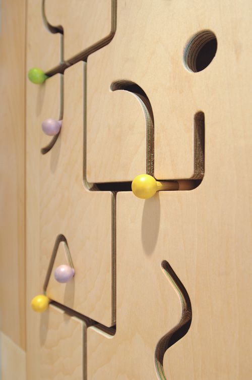 a wooden door with metal handles and knobs on the handle, as well as several different colored balls attached to it