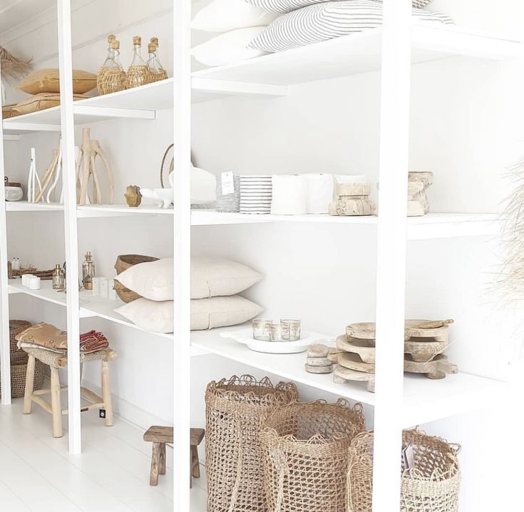 the shelves are filled with baskets and other items in white painted rooms, such as wicker baskets