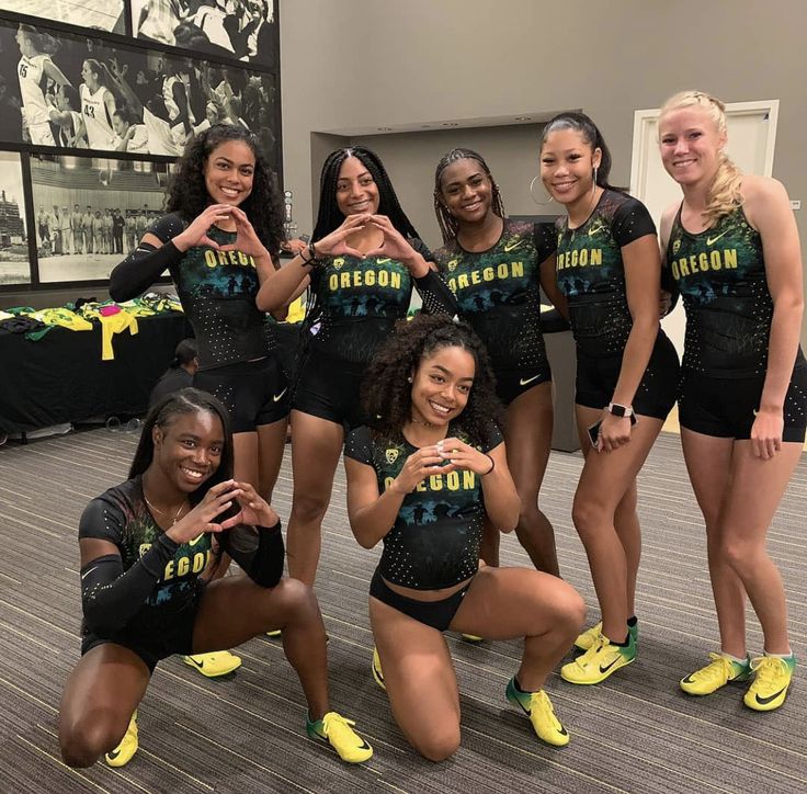 the cheerleaders pose for a photo in their black outfits and neon yellow shoes