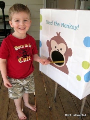 a young boy standing next to a sign with a monkey on it