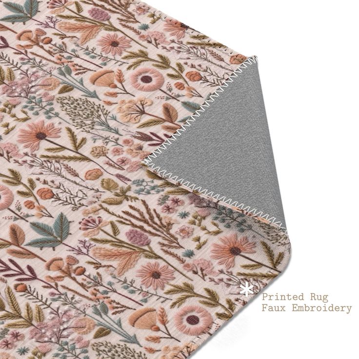 a close up of a flowered fabric on a white surface with grey backings