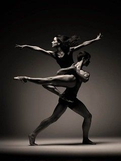 two dancers in black and white pose for the camera