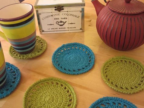 four crocheted coasters and a teapot on a table