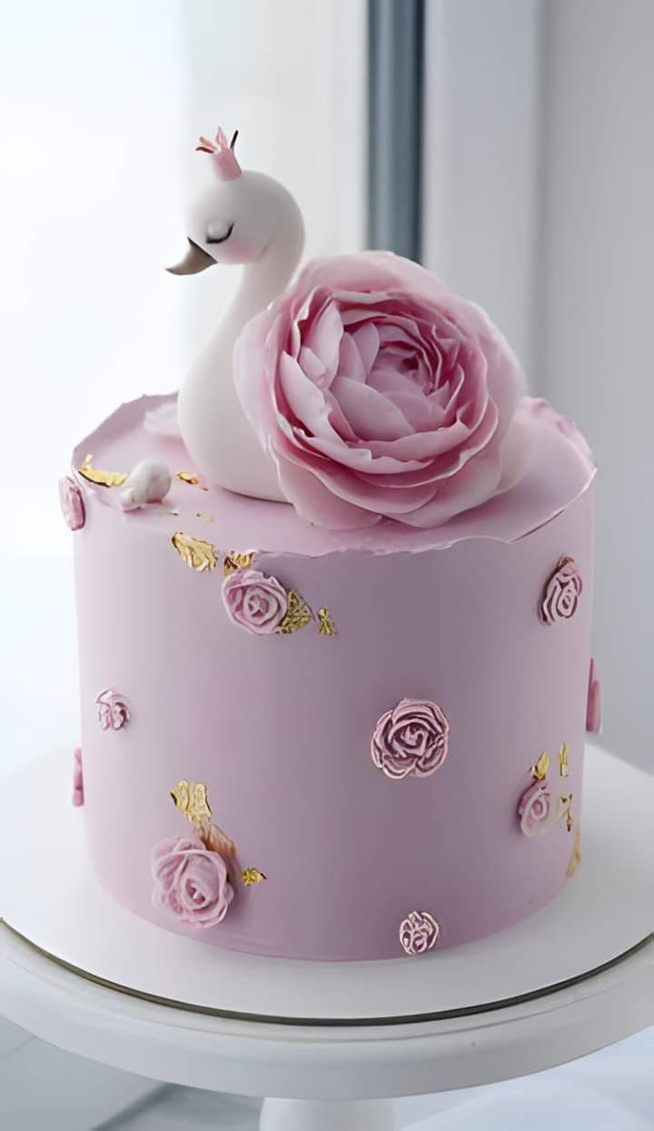 a pink cake decorated with flowers and a white swan