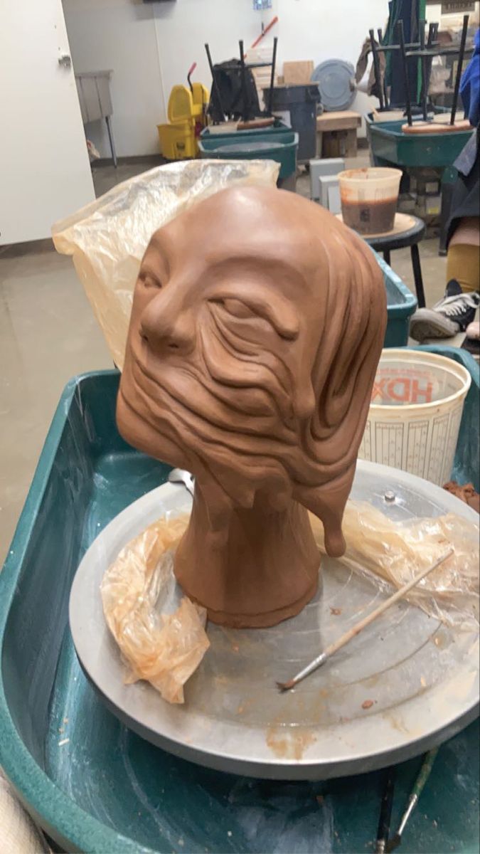 a clay sculpture is being made in a studio