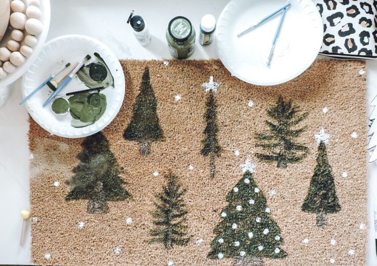 a place mat decorated with christmas trees and snowflakes on a table next to other decorations