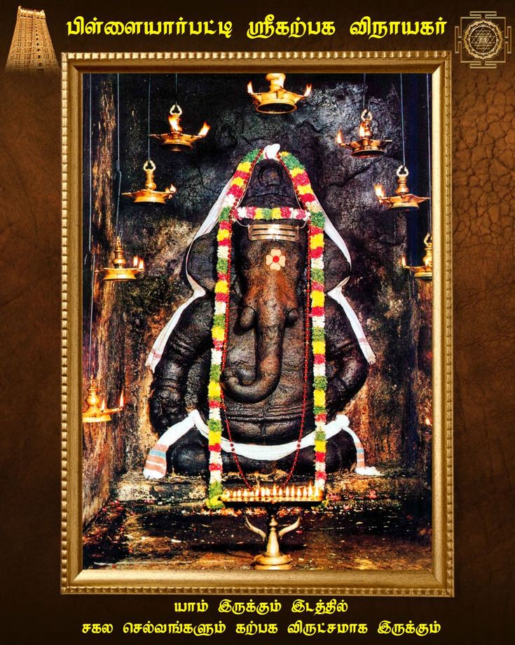 an elephant with decorations on its body in front of a wall and some candles around it