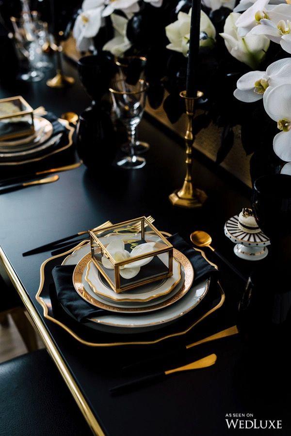 black and gold table setting with white flowers