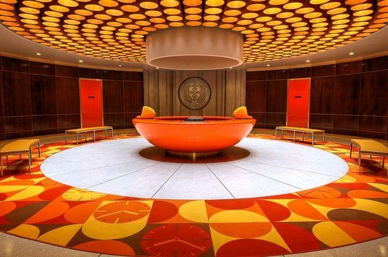 an orange and yellow circular room with chairs