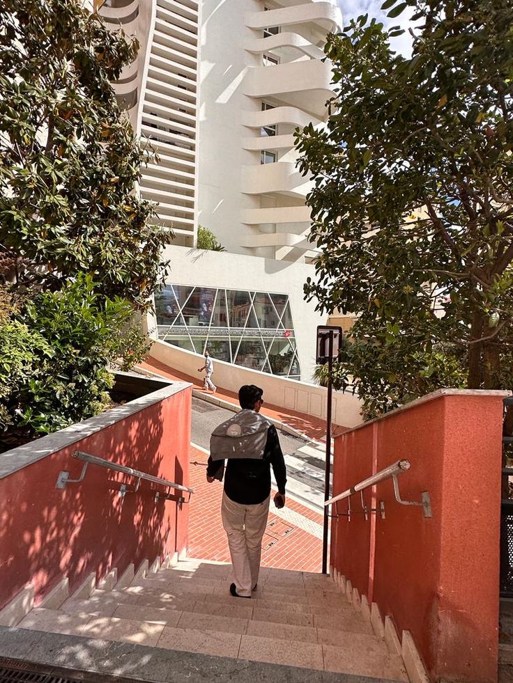 a woman walking up some stairs in front of a tall building